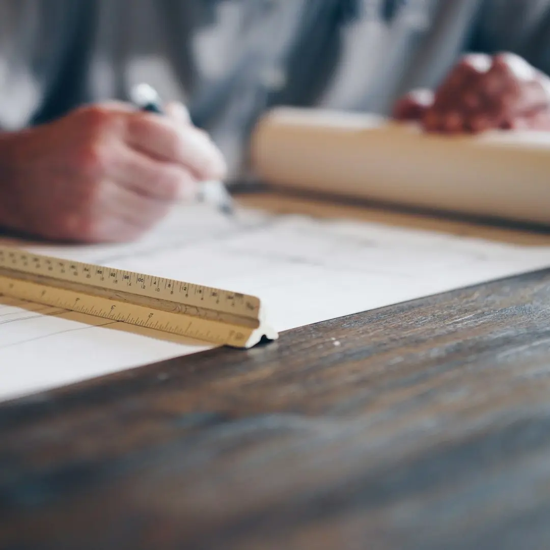 person drafting on blueprint